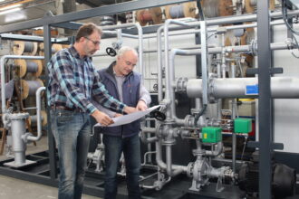 AURA engineers reviewing plans on the shop floor